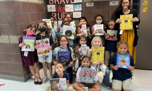 students hold their new books